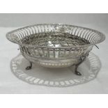 A silver bon bon dish having reeded rim, pierced decoration and trefoil serpent feet, Sheffield