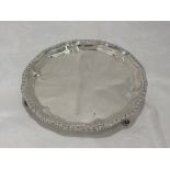 A Georgian silver card tray having pie crust rim with gadrooned decoration and trefoil hoof feet,