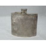 A silver hip flask of half moon form having engine turned decoration and monogrammed cartouche