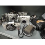 Four Canon cameras. A Sureshot 105 zoom, three Powershot G3, camera bag etc