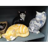 Three vintage ceramic cat figures one black and white tabby a ginger cat and transfer printed blue
