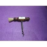 A vintage cork screw having turned wood handle and brush