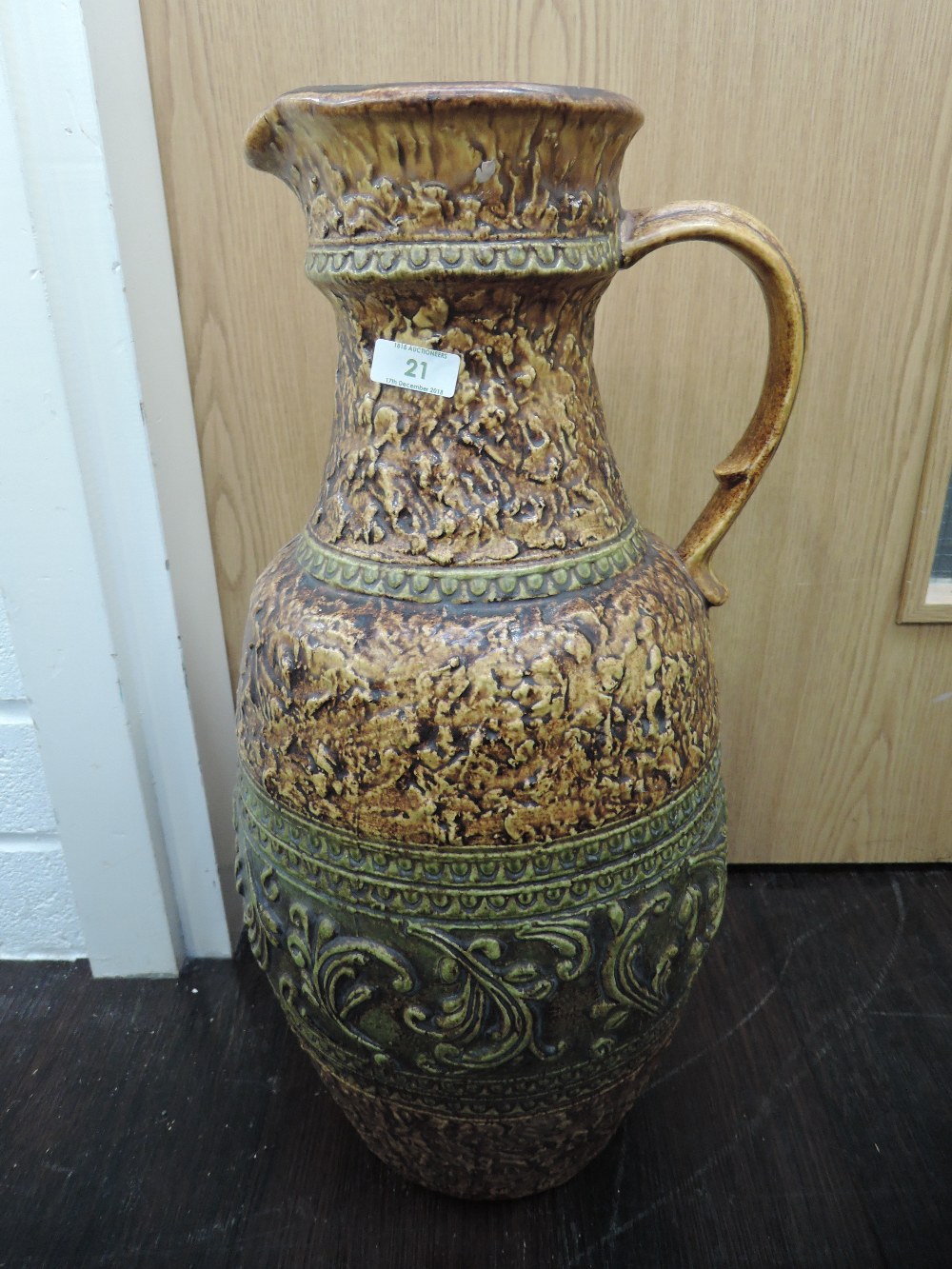 A large continental pottery jug having moulded leaf and swirl decoration, stamped Jasba 1680 55