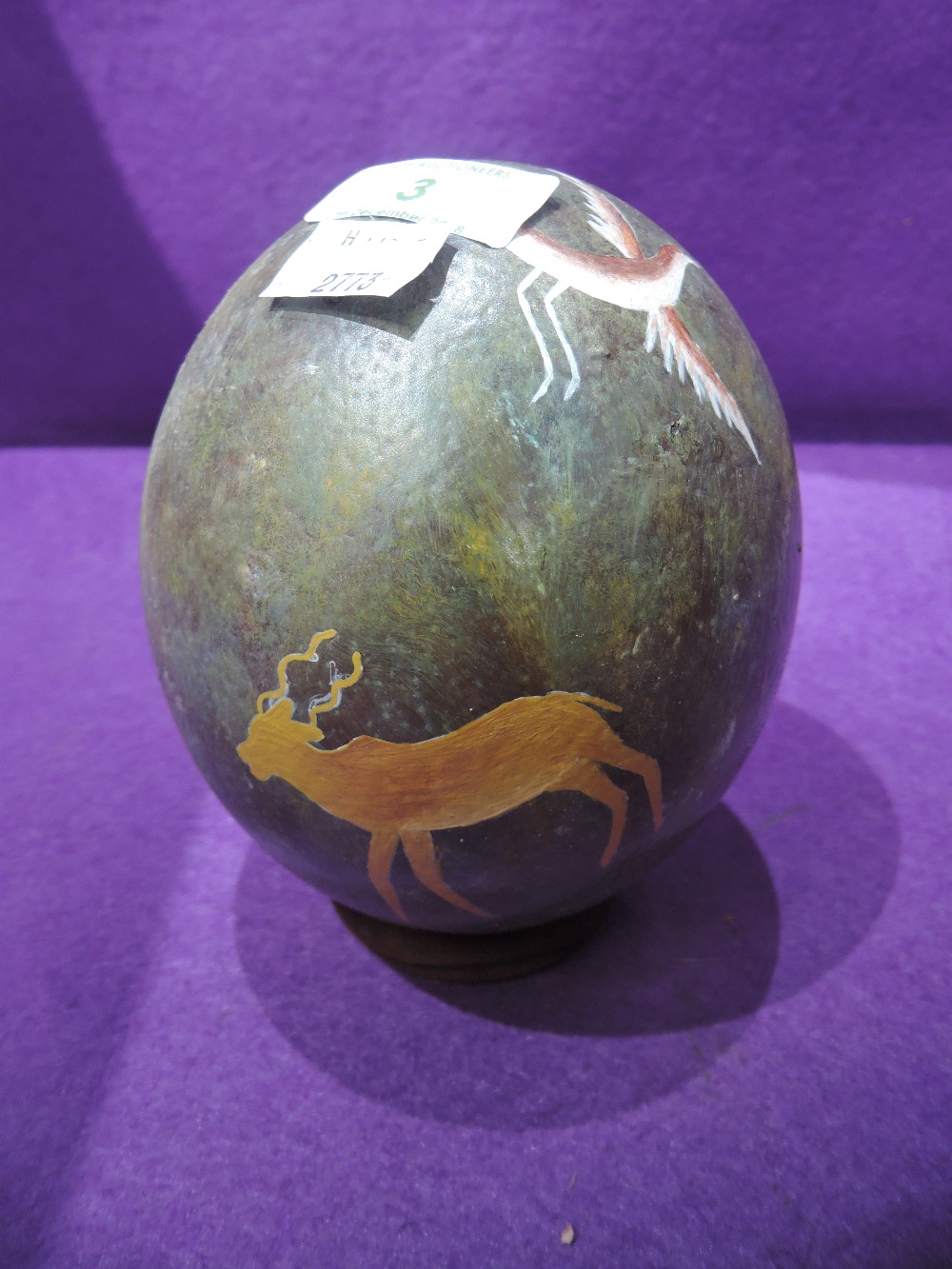 A hand decorated Ostrich or Emu egg with African wild life imagery