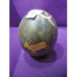 A hand decorated Ostrich or Emu egg with African wild life imagery