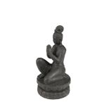 AN ASIAN CARVED LIMESTONE FIGURE OF A DEITY, in prayer, on a circular socle. 39cm high