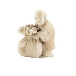 A JAPANESE CARVED IVORY MINIATURE GROUP, Meiji Period, modelled as a street merchant rounding a rice