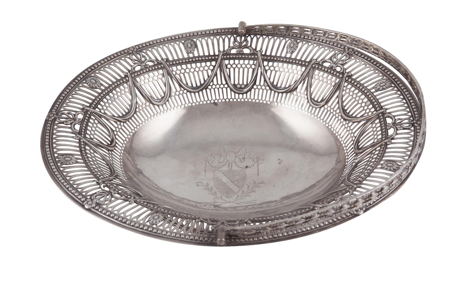 AN IRISH GEORGE III PIERCED SILVER SWING HANDLED FRUIT BASKET, Dublin c.1780, mark of John Lloyd, of