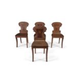 A SET OF FOUR GEORGE III MAHOGANY HALL CHAIRS, the shield shaped back painted with a central
