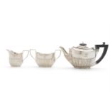 AN EDWARDIAN MATCHED THREE PIECE SILVER BACHELOR'S TEA SERVICE, comprising teapot, creamer and sugar