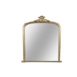 A VICTORIAN GILTWOOD OVERMANTLE MIRROR, of arched rectangular form, surmounted with leaf carved