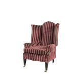 AN UPHOLSTERED WINGBACK ARMCHAIR, with close nailed striped upholstery, raised on square tapering