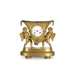Reloj de sobremesa Imperio en bronce dorado, en el que dos ángeles sujetan una cesta que hace las