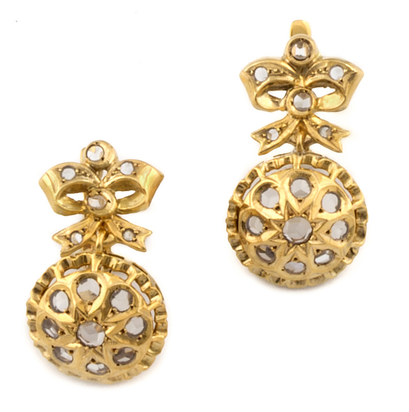 Pendientes con rosetón que pende de lazo con zafiros blancos en oro amarillo de 18K. Longitud: 2,3