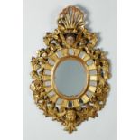 Espejo ovalado en madera tallada, estucada, dorada y policromada. Trabajo español S. XVIII
