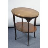 An Edwardian inlaid-mahogany oval two-tier occasional table on square tampered legs, 23¾” wide.