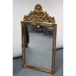 A reproduction gilt frame rectangular wall mirror with scroll & shell surmount, 26½” x 49½”.