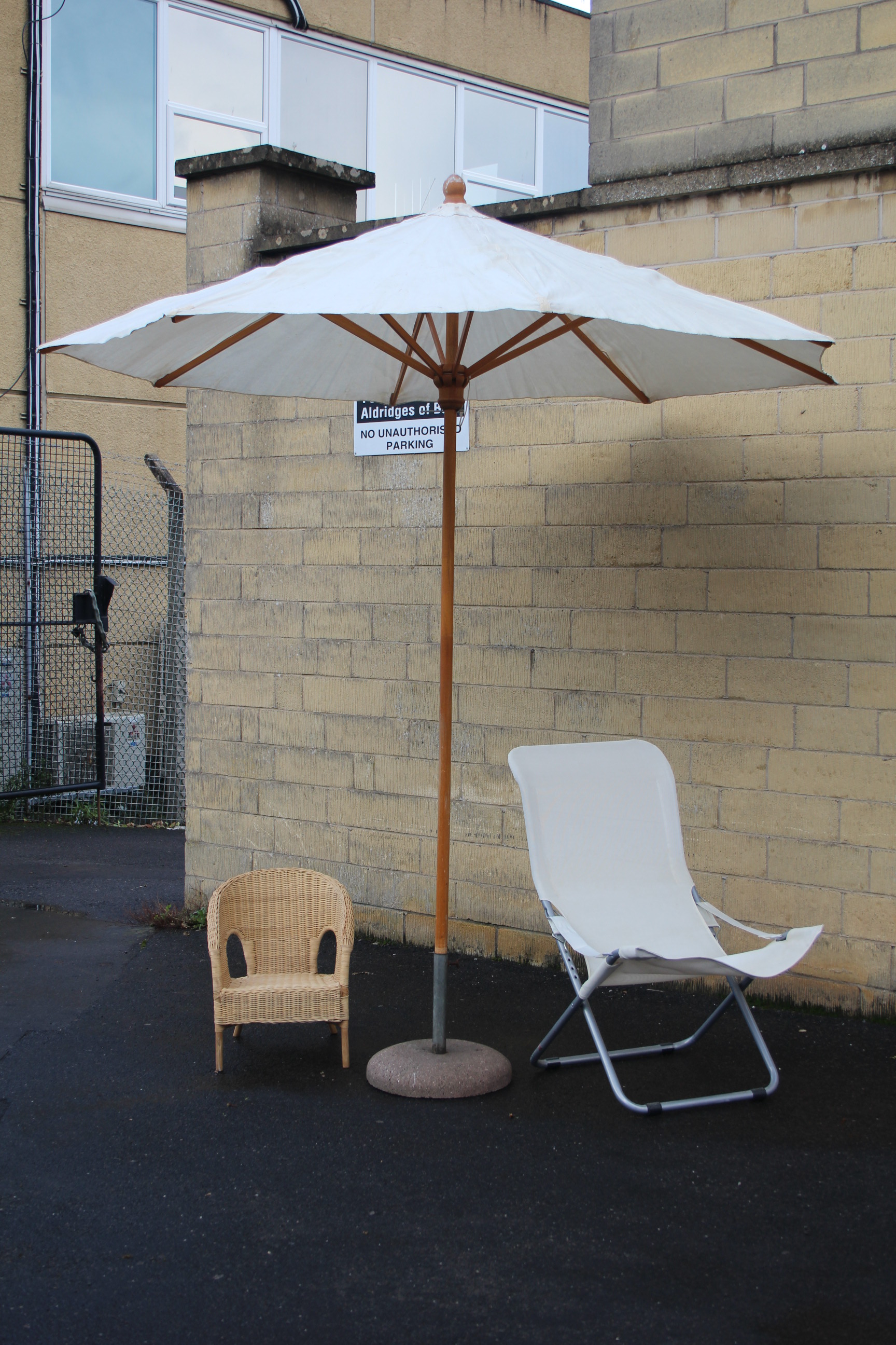 A garden parasol with base; a sun lounger; & a rattan child’s conservatory chair.