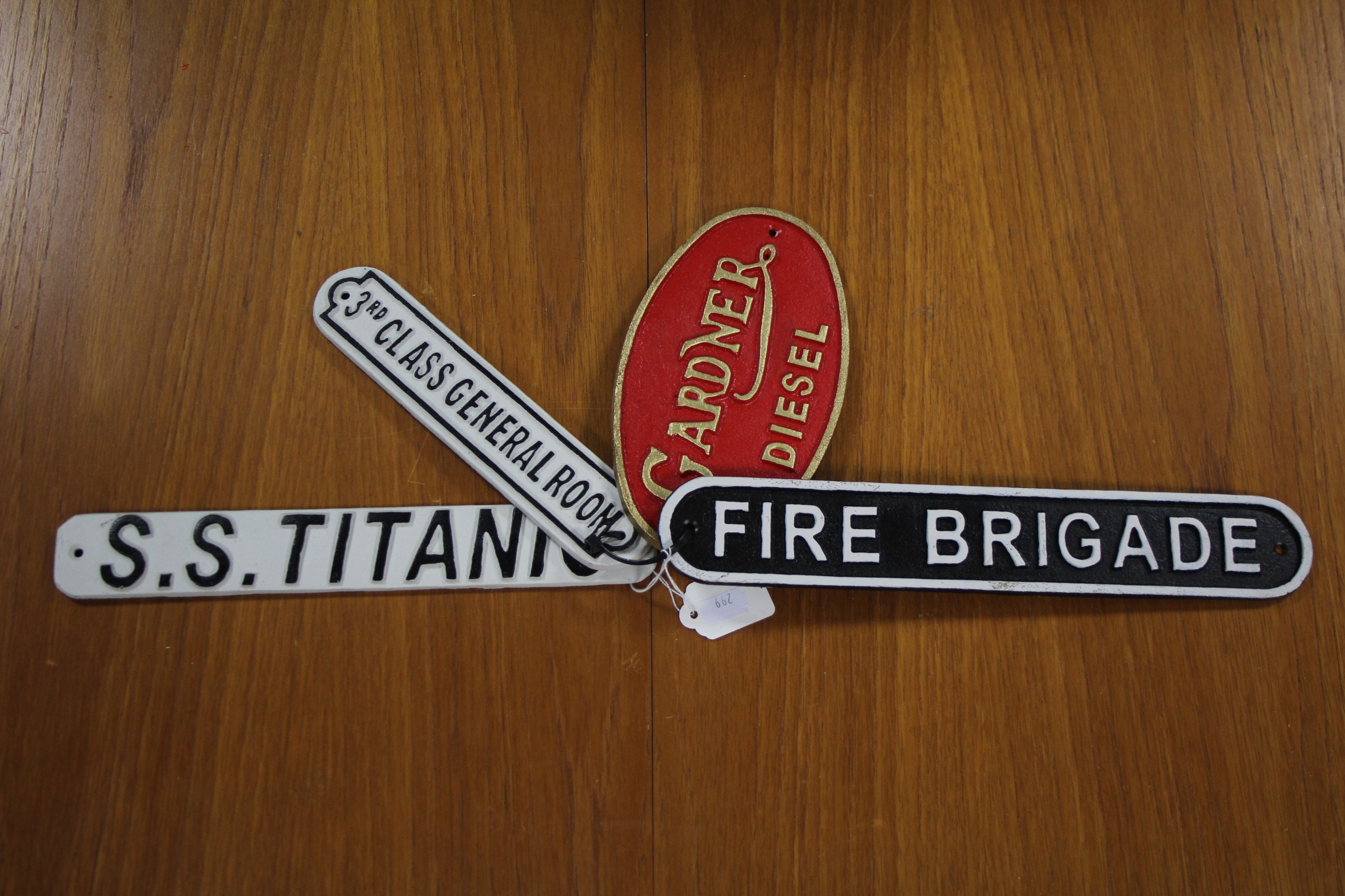 Four various reproduction painted cast-iron signs (various sizes).