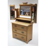 A late Victorian walnut dressing chest with triple panel mirror to the stage back, & fitted three