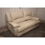 A cream leather three-seater electrically-operated reclining sofa, 84” long.