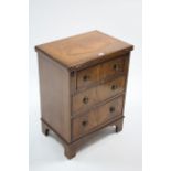 A mahogany bachelor's chest, with hinged fold-over top, fitted three long graduated drawers with