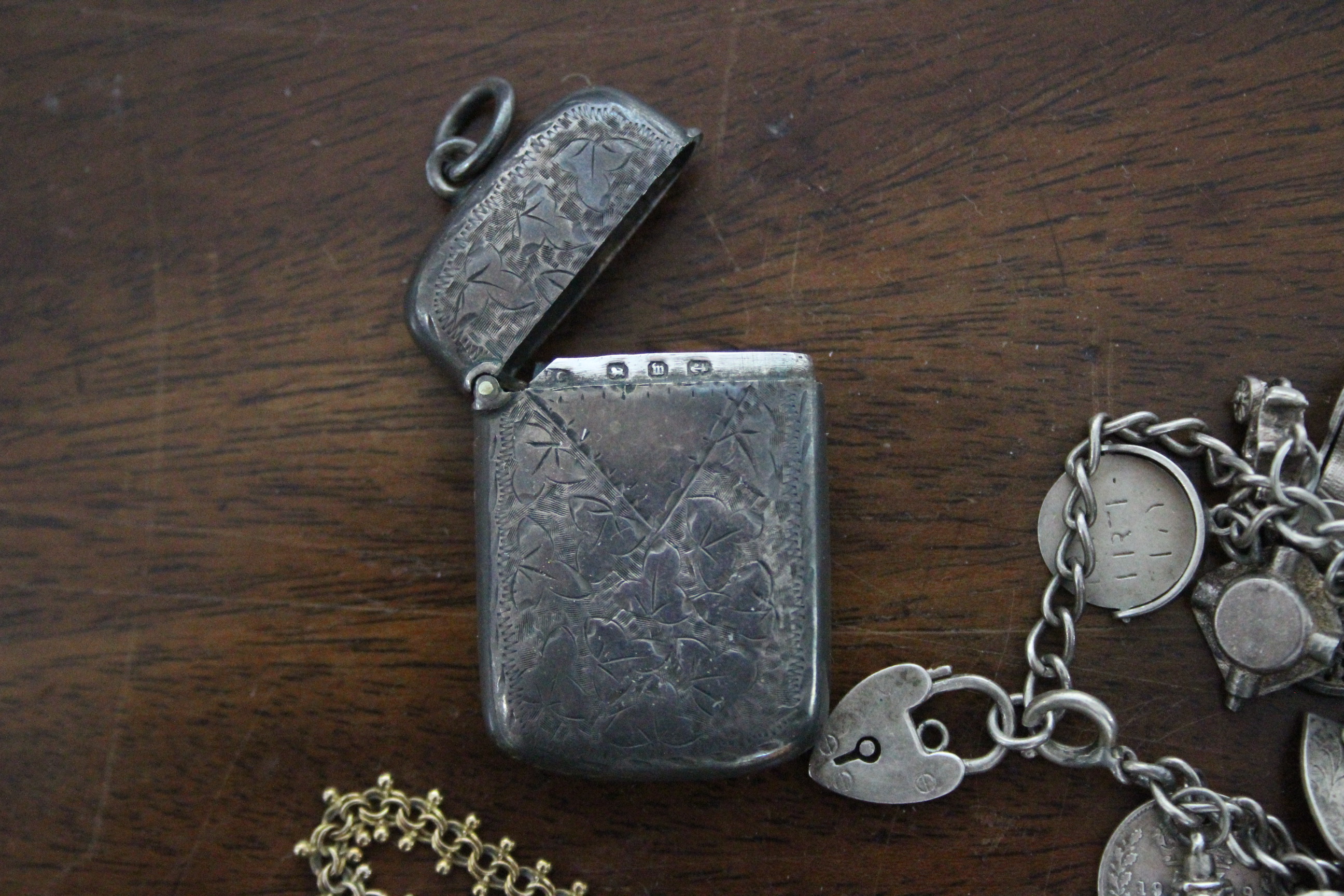 A silver engraved Vesta case; a white-metal charm bracelet; a yellow-metal child’s bracelet & - Image 2 of 12