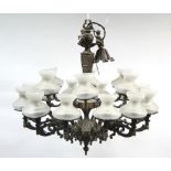 A bronzed eighteen-branch chandelier with fluted & vase-turned centre column & with frosted glass