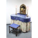A kidney-shaped dressing table with plain blue & floral printed drapes, 45” wide & a matching stool.
