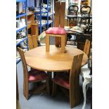 A contemporary wood dining table with circular top & on three shaped supports with triform base