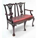 A 19th century-style carved mahogany two-seater settee with pierced & shaped splats to the open back