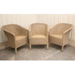 A set of three wicker tub-shaped conservatory chairs.
