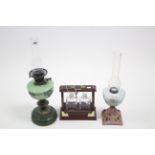 Two vintage oil table lamps, one with floral painted green glass reservoir; together with a
