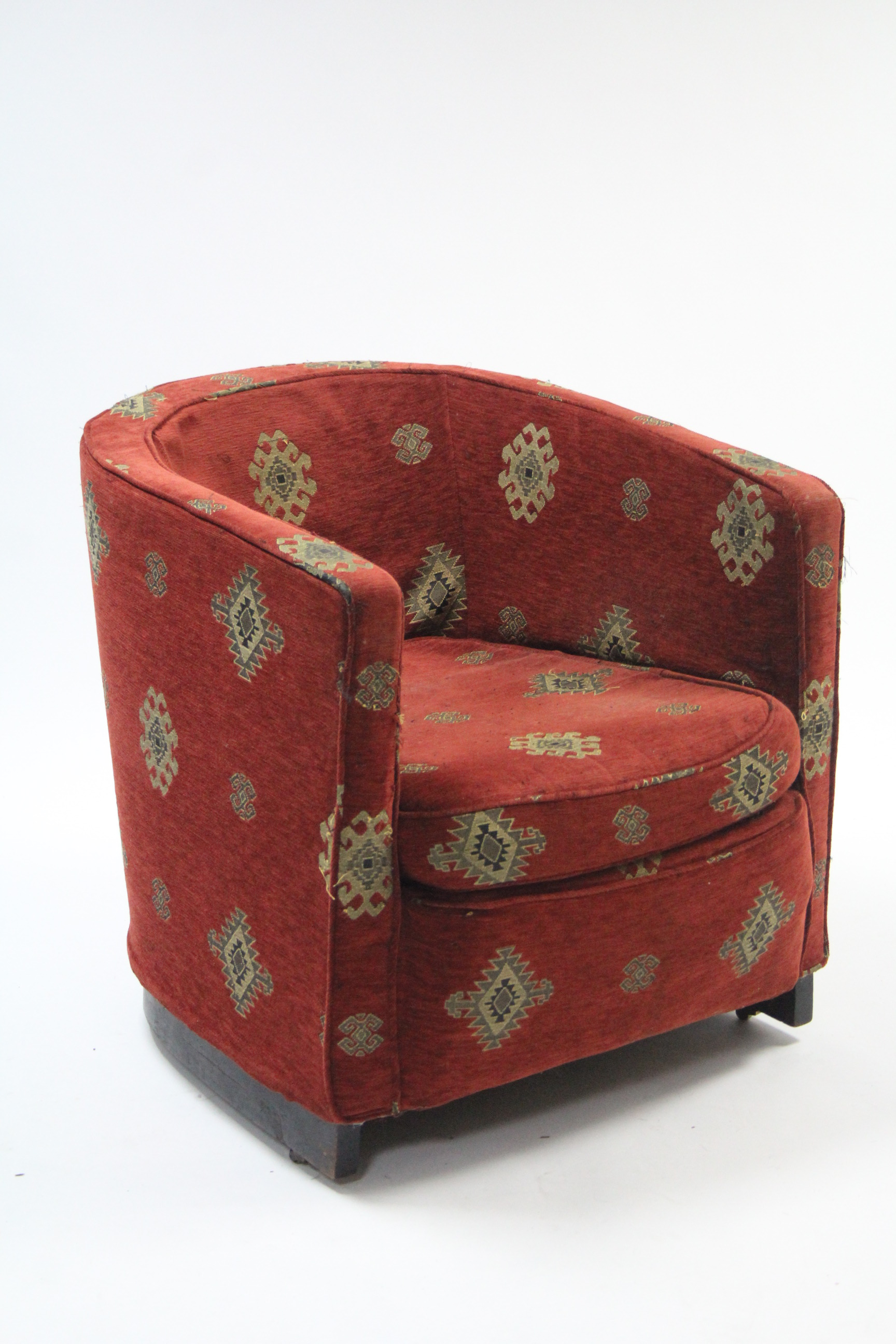 A tub-shaped chair upholstered crimson geometrical material.