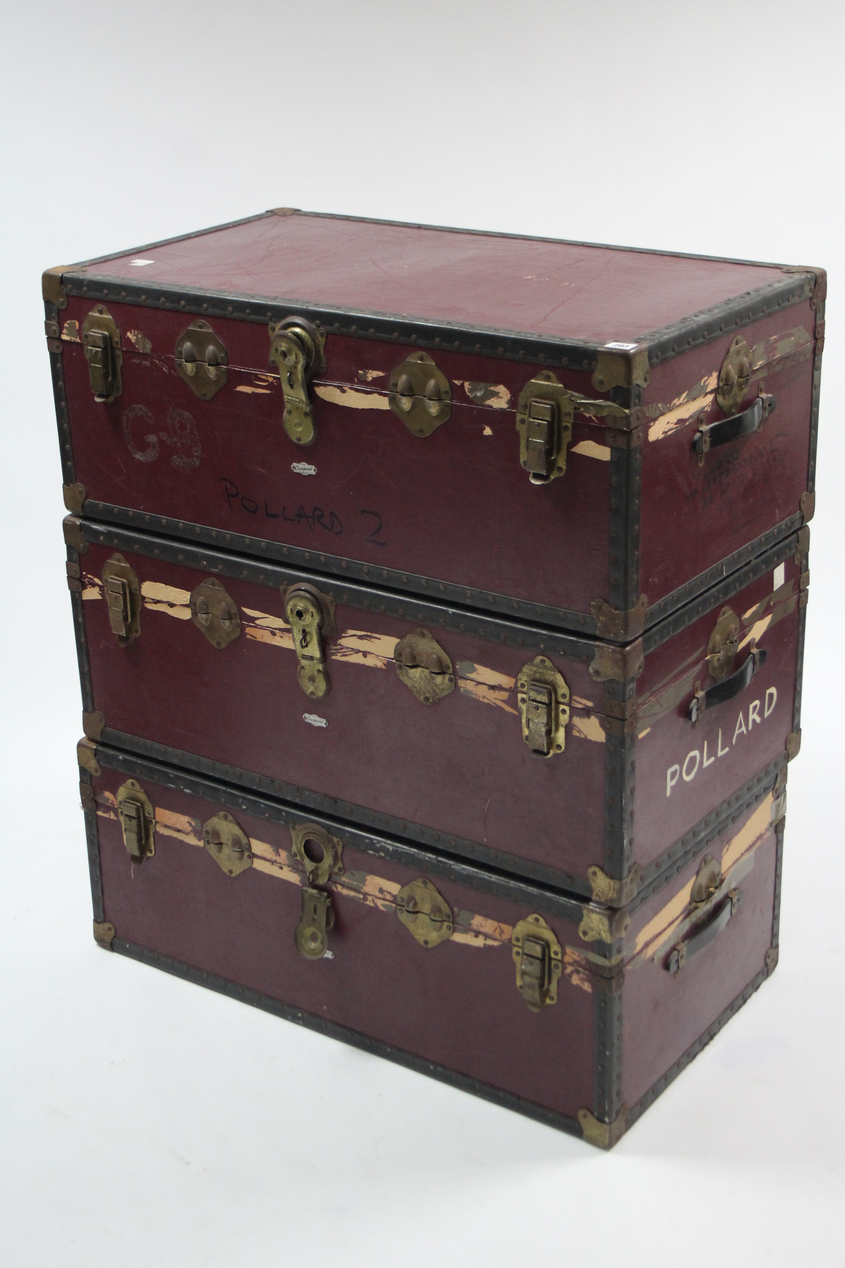 Three early-mid 20th century crimson-finish travelling trunks, each 36” wide (slight faults).