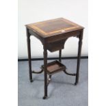 A 19th century inlaid-rosewood needlework table with hinged rectangular top, & on square tampered