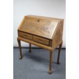 A Chinese carved hardwood bureau with fitted interior enclosed by fall-front above two short