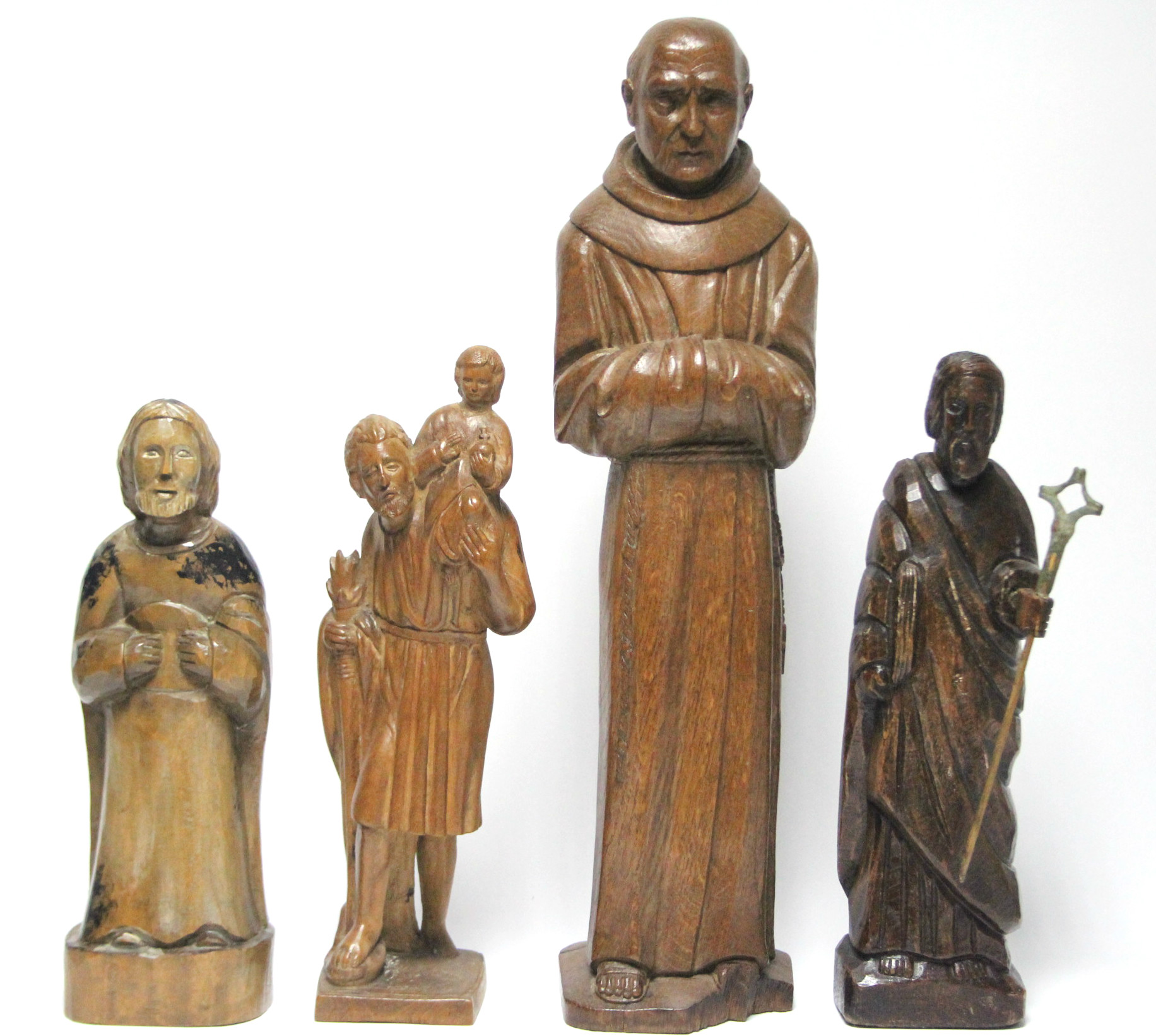 A carved oak standing figure of a monk, 20” high; & three other smaller carved wood religious