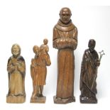 A carved oak standing figure of a monk, 20” high; & three other smaller carved wood religious