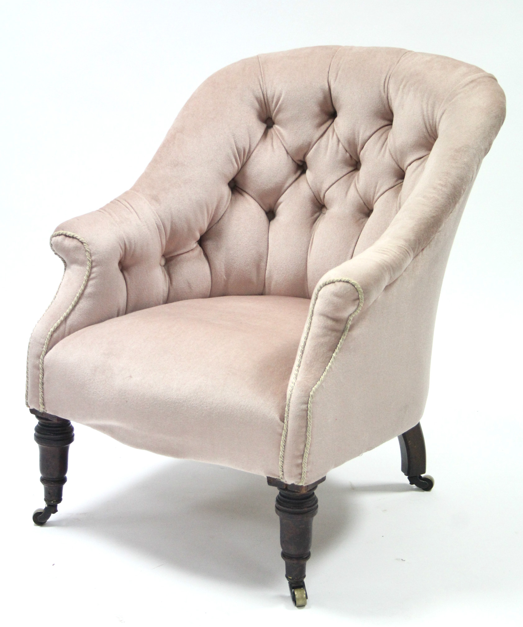 A mid-Victorian tub-shaped armchair, the buttoned back, arms & sprung seat upholstered salmon-pink