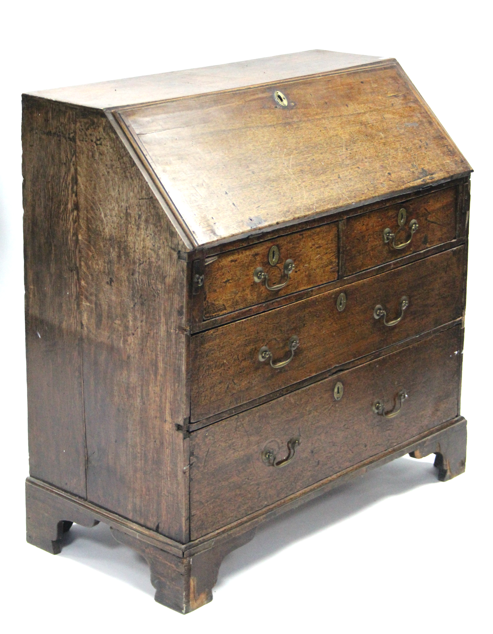 A late 18th century oak bureau with fitted interior enclosed by a sloping fall front above two short