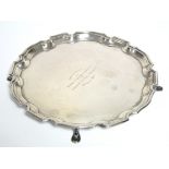 An 8” diam. waiter with engraved inscription, raised pie-crust border, & on four pad feet;