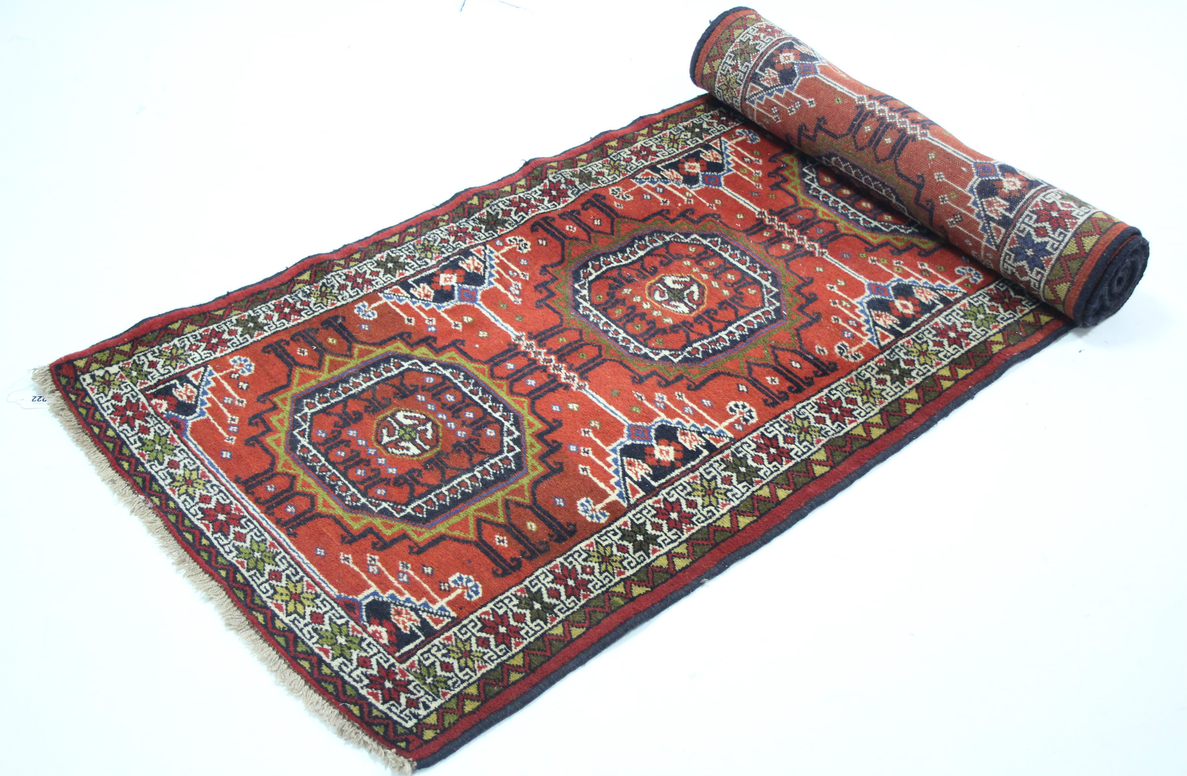 A modern Persian corridor runner with row of six multi-coloured panels on a coral-red ground; 9’ 10”