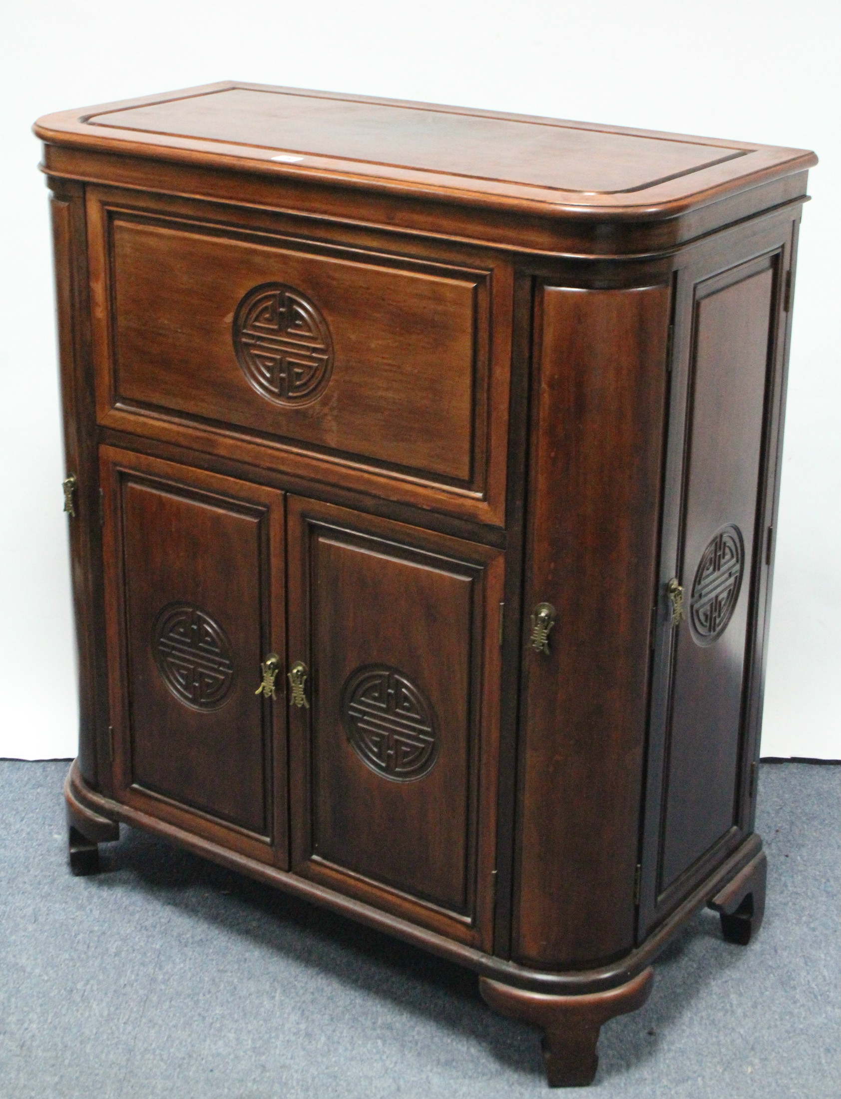 An early/mid-20th century Chinese carved hardwood drinks cabinet with lift top & fall front,