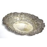 An Edwardian oval shallow dish, the wide borders embossed with flowers & scrolls, 10” x 7½”;