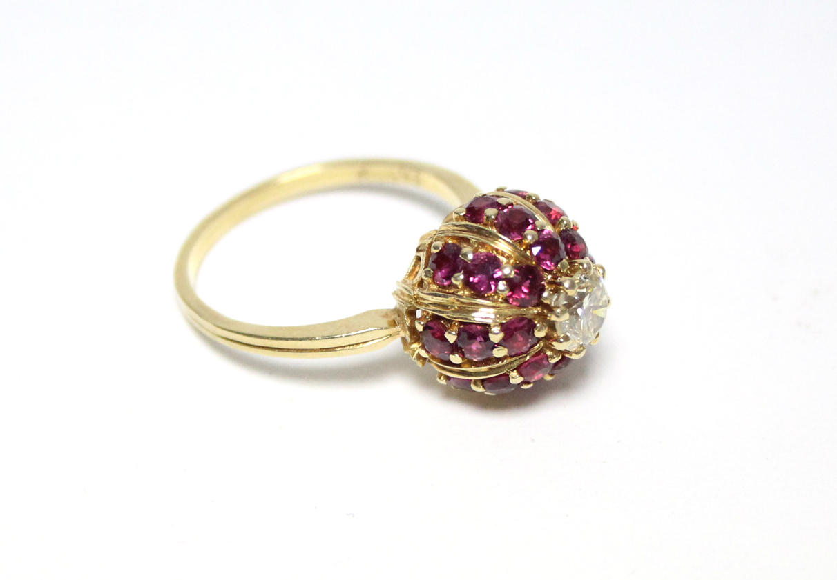 An 18ct. gold ring, the domed head set twenty four small rubies, & central diamond of approx. 0.