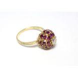 An 18ct. gold ring, the domed head set twenty four small rubies, & central diamond of approx. 0.