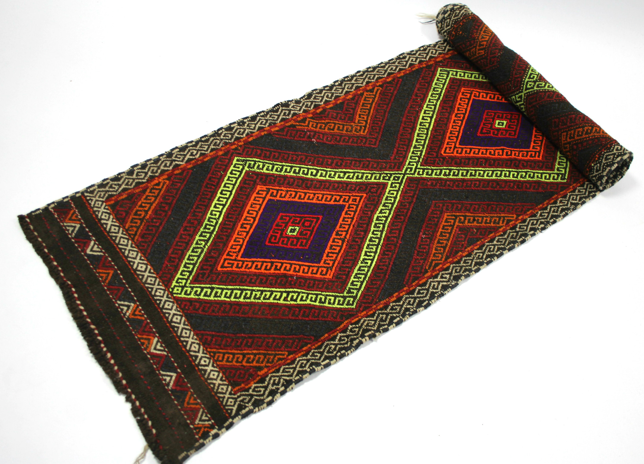 A Suzni Kelim runner of bright multi-coloured geometric design, with row of four lozenges within