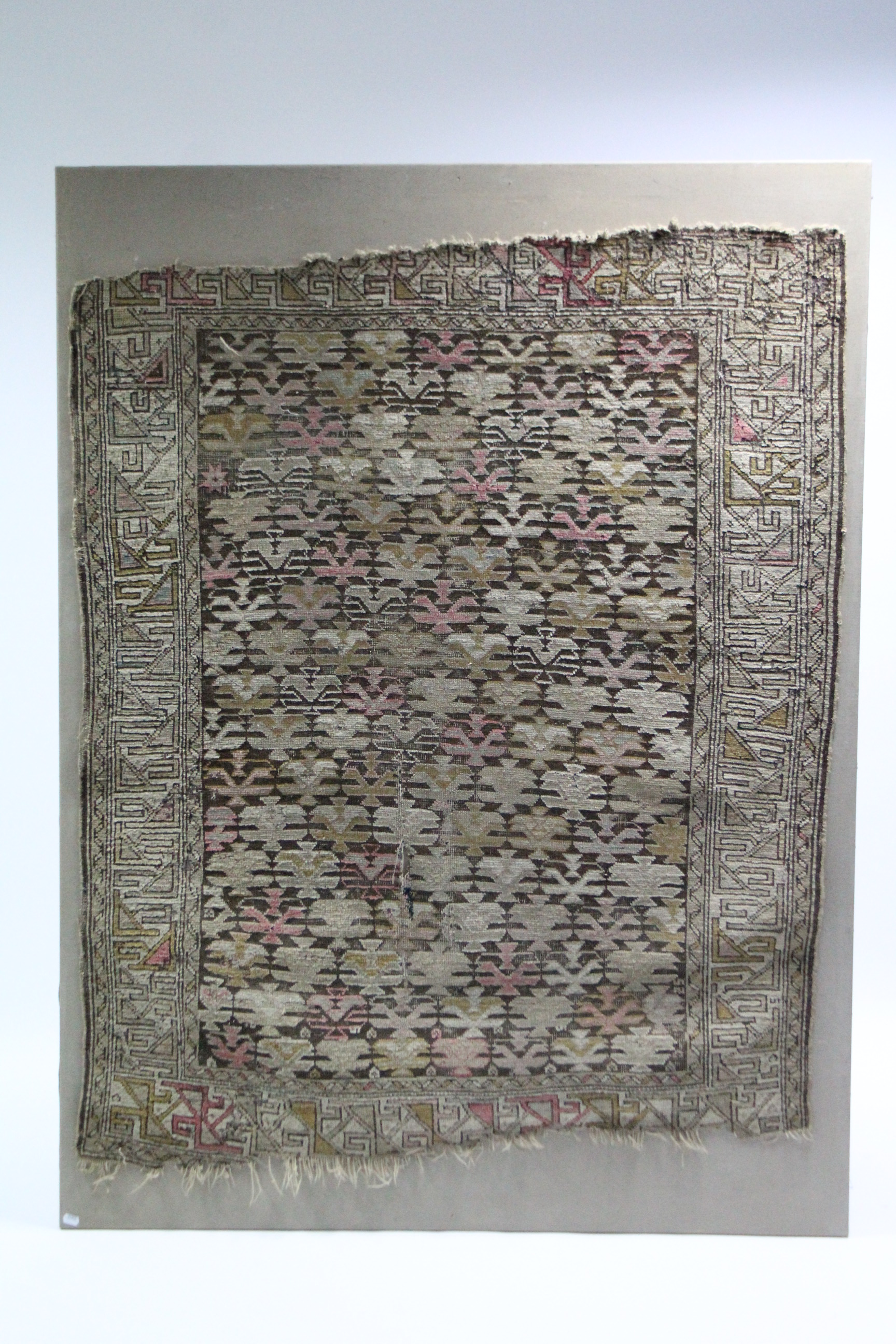 An antique Kelim rug of fawn ground, 4’ 6” x 3’ 10” (worn), applied to a 5’4½” x 4’ canvas.