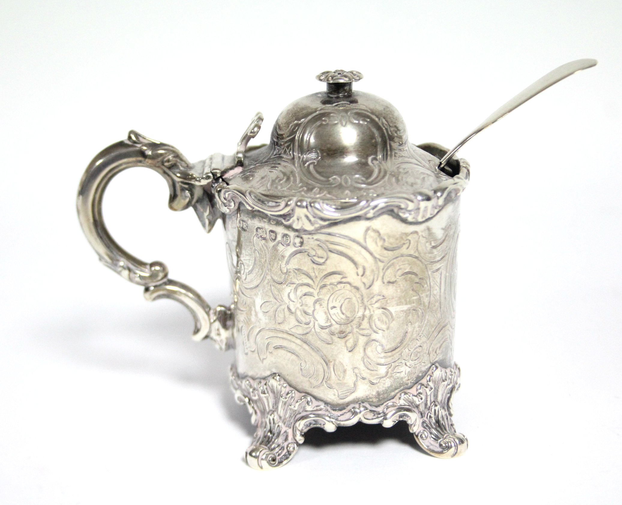 A Victorian cylindrical mustard pot with engraved floral decoration, domed hinged cover, scroll